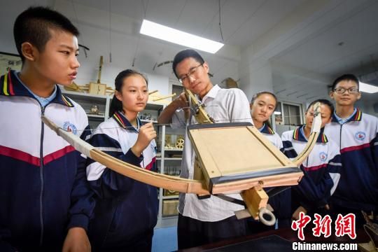  图为兰州市外国语中学的青年生物教师高飞指导学生们进行发明创造。　郁婕 摄